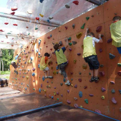 Quatre enfants grimpent sur le mur de bloc