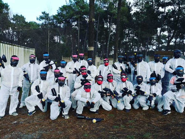 Groupe d'adulte devant le terrain de paintball