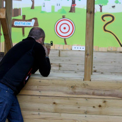 Un homme qui vise la cible avec un pistolet de biathlon